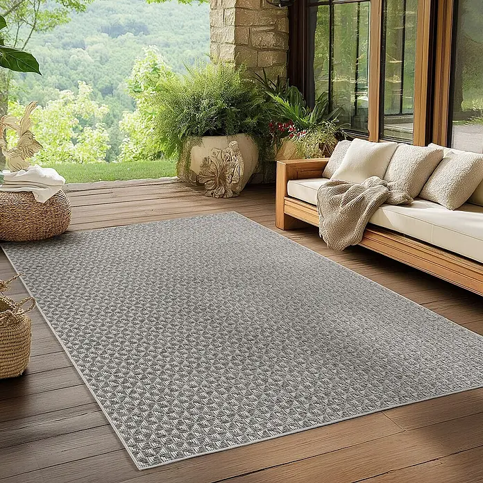 Outdoor-Teppich Ibiza III - Grau, 340 x 240 cm, 100 % Polypropylen - Der graue Teppich mit geometrischem Muster liegt auf einer hölzernen Terrasse mit Möbeln und Pflanzen.