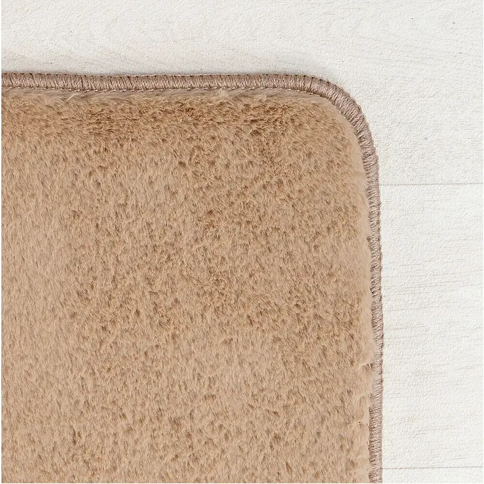 Kurzflorteppich Joy - Beige, 280 x 200 cm, 100 % Polyester - Detailaufnahme eines beigen Teppichs mit weicher Textur und eingefasstem Rand auf hellem Untergrund.
