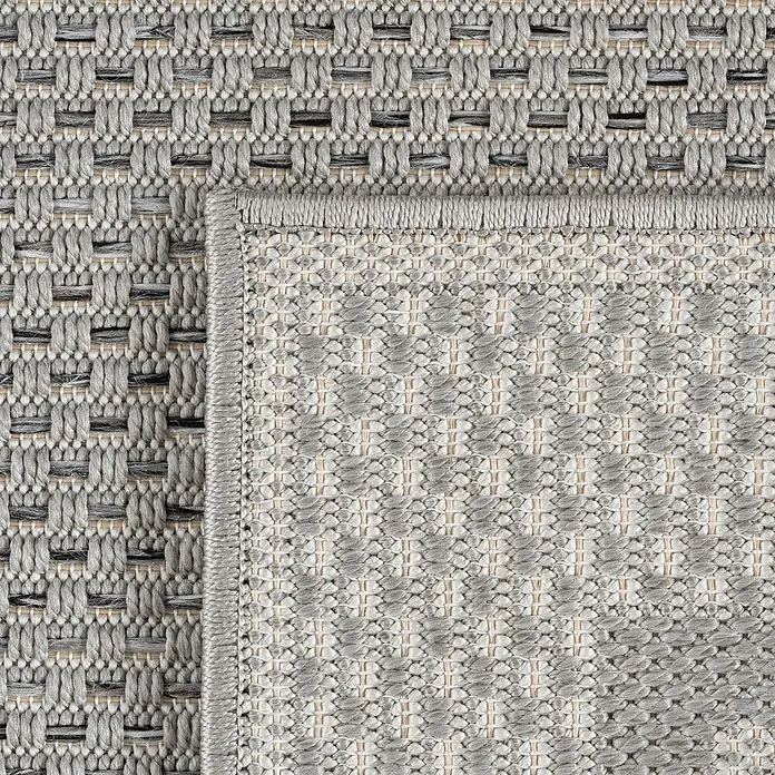 Outdoor-Teppich Desert 1304 - Grau, Durchmesser: 160 cm, 100 % Polypropylen - Nahaufnahme eines gewebten grauen Teppichs mit einem Muster aus ineinandergreifenden Rechtecken und einer dezenten Bordüre.