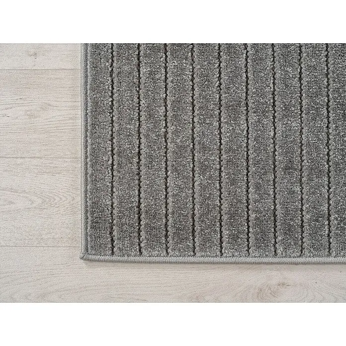 Outdoor-Teppich Nova II - Silver, Durchmesser: 80 cm, 100 % Polypropylen - Detailansicht eines grauen Teppichs mit Streifenmuster, der auf einem hellen Holzboden liegt. Der Teppich hat eine feine Bordüre und eine weiche Textur.