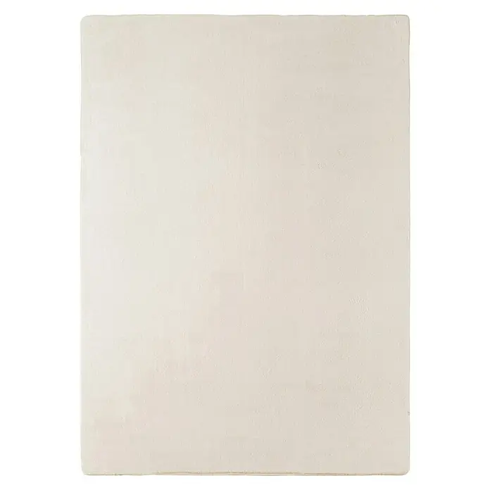 Kurzflorteppich Joy - Creme, 280 x 200 cm, 100 % Polyester - Eine Nahaufnahme einer strukturierten, cremefarbenen Wand, die eine schlichte und elegante Ästhetik für diverse Designprojekte bietet.