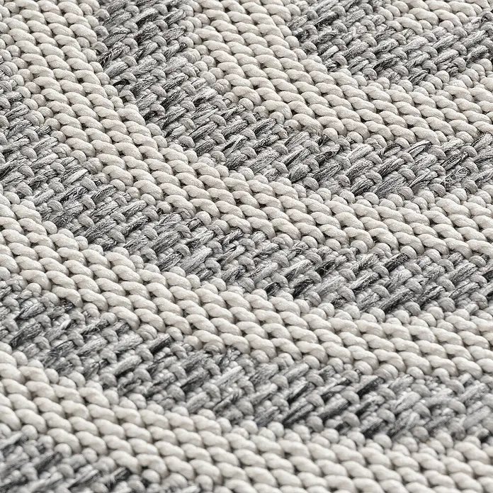 Outdoor-Teppich Desert 1301 - Grau, 230 x 160 cm, 100 % Polypropylen - Nahaufnahme eines gestreiften Teppichs in Grau- und Beigetönen, der eine interessante Textur aufweist.