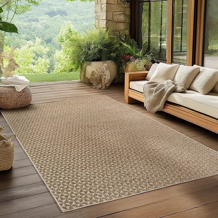 Outdoor-Teppich Ibiza III - Beige, 170 x 120 cm, 100 % Polypropylen - Ein rechteckiger, brauner Outdoor-Teppich mit geometrischem Muster liegt auf einer Terrasse mit Möbeln und Pflanzen.