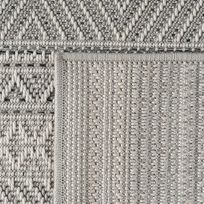 Outdoor-Teppich Desert 1303 - Grau, 200 x 140 cm, 100 % Polypropylen - Nahaufnahme eines grauen Teppichs mit geometrischen Mustern und einer sichtbaren Webstruktur, die die Textur hervorhebt.