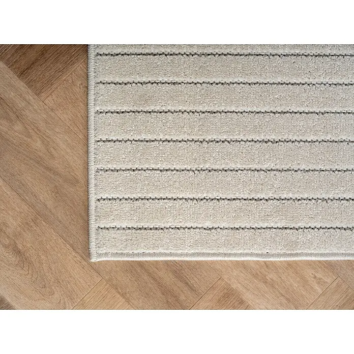 Outdoor-Teppich Nova I - Cream, Durchmesser: 200 cm, 100 % Polypropylen - Detailansicht eines gestreiften Teppichs auf einem Holzboden, der die Textur und das Design des Teppichs hervorhebt.