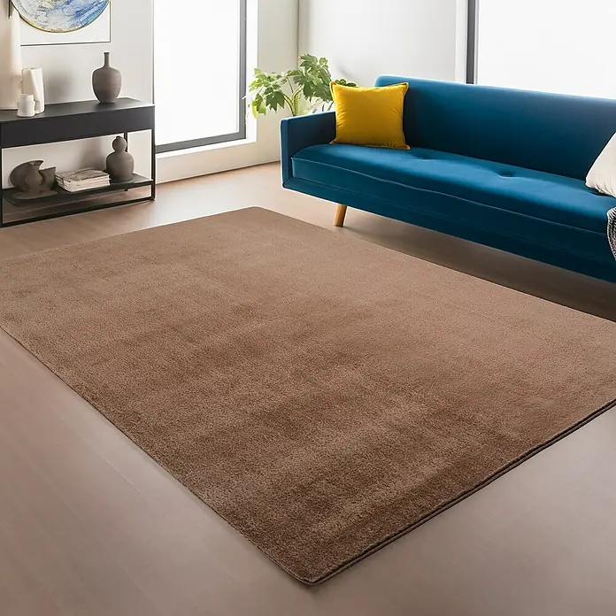 Kurzflorteppich Joy - Mokka, 280 x 200 cm, 100 % Polyester - Ein brauner Teppich liegt im Wohnzimmer und ergänzt das blaue Sofa und die moderne Einrichtung.
