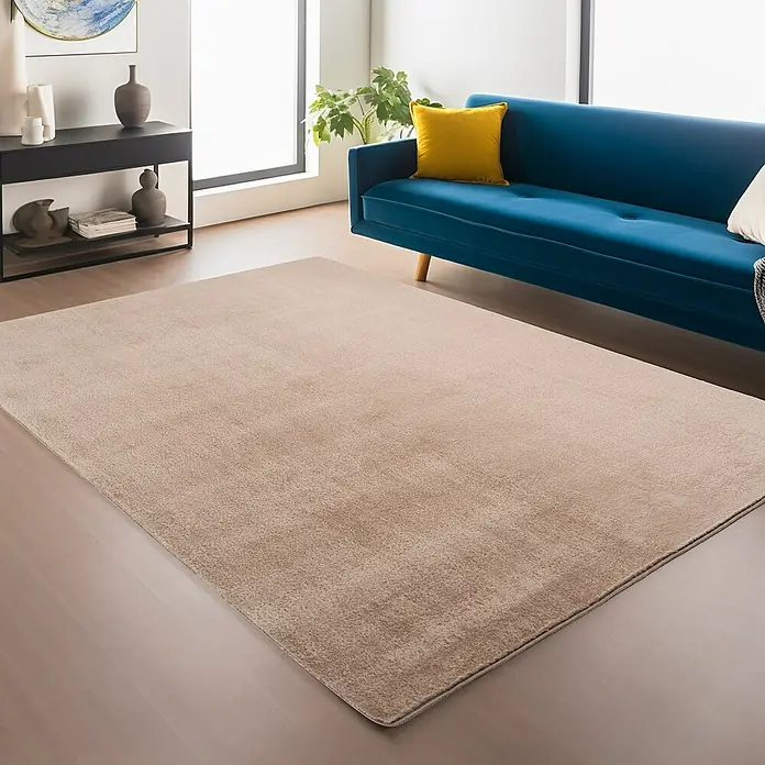 Kurzflorteppich Joy - Beige, 280 x 200 cm, 100 % Polyester - Ein stilvoller, beigefarbener Teppich liegt im Wohnzimmer und ergänzt das moderne Interieur mit blauem Sofa und minimalistischen Möbeln.
