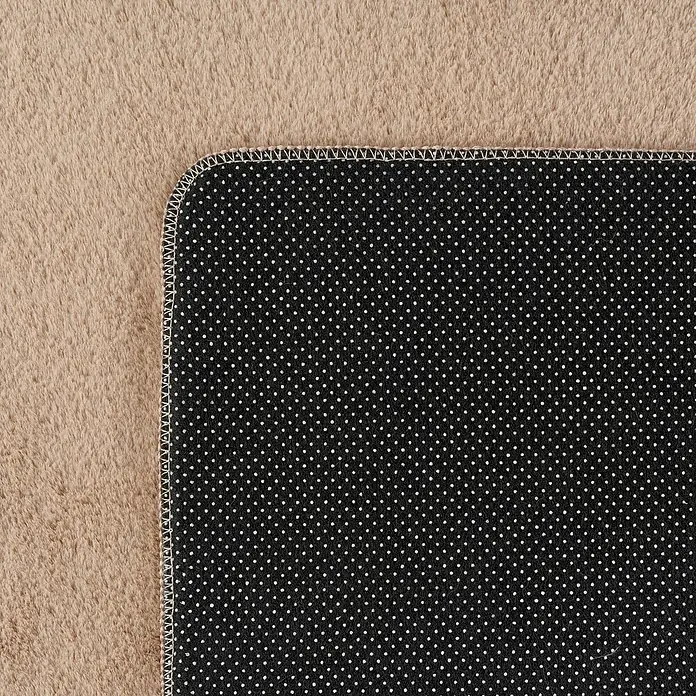 Kurzflorteppich Joy - Beige, 280 x 200 cm, 100 % Polyester - Nahaufnahme der Rückseite eines Teppichs mit schwarzen Punkten auf beigem Hintergrund, die die hochwertige Verarbeitung und das Design hervorhebt.
