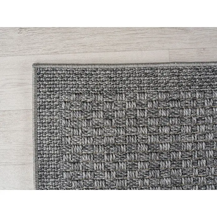 Outdoor-Teppich Ibiza I - Grau, 170 x 120 cm, 100 % Polypropylen - Nahaufnahme eines grauen gewebten Teppichs, der auf einem Holzboden liegt. Der Teppich hat ein interessantes, detailliertes Muster.