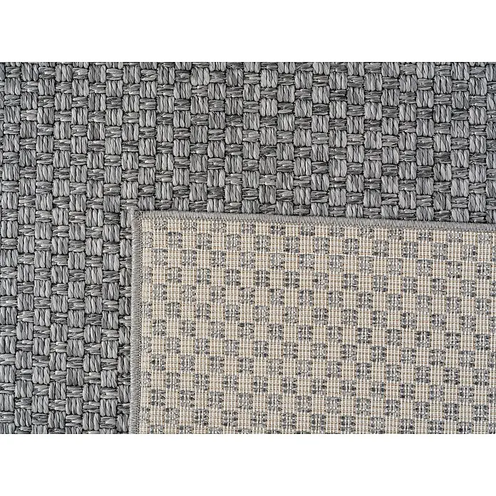 Outdoor-Teppich Ibiza III - Grau, 170 x 120 cm, 100 % Polypropylen - Nahaufnahme eines grauen Outdoor-Teppichs mit gewebter Textur und einem umgeschlagenen Rand, der die Unterseite zeigt.