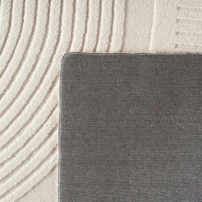 Kurzflorteppich Pompei 1612 - Creme, 340 x 240 cm, 100 % Polyester - Nahaufnahme eines Teppichs mit beigen, wellenförmigen Linien und einer grauen, strukturierten Rückseite.