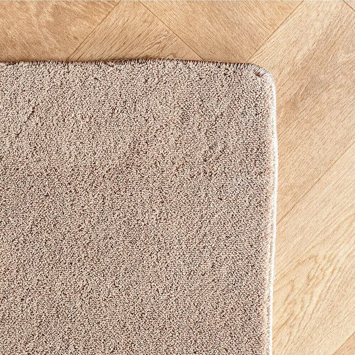 Kurzflorteppich Pompei 1614 - Beige, 230 x 160 cm, 100 % Polyester - Nahaufnahme eines beigefarbenen Teppichs auf einem Holzboden, der die Textur und die neutrale Farbpalette des Teppichs hervorhebt.