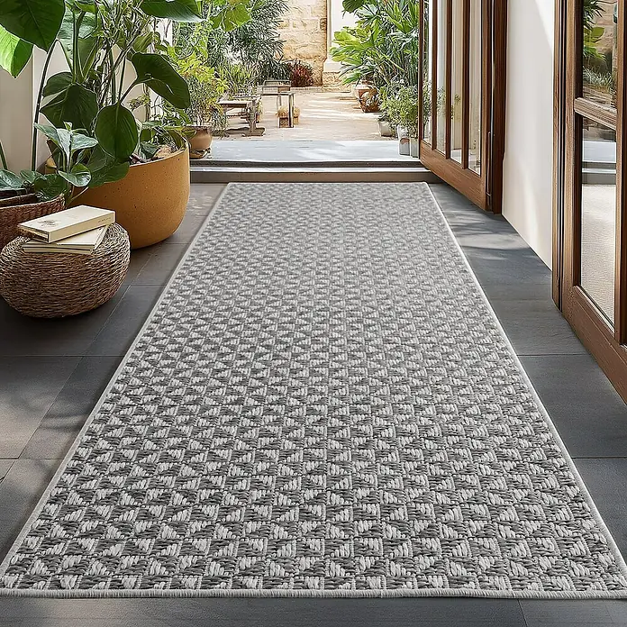 Outdoor-Teppich Ibiza II - Grau, 150 x 80 cm, 100 % Polypropylen - Ein grauer Teppich mit geometrischem Muster liegt in einem stilvollen Durchgangsbereich. Der Teppich verleiht dem Raum eine moderne Note.