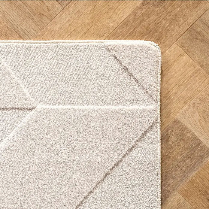 Kurzflorteppich Pompei 1613 - Creme, 230 x 160 cm, 100 % Polyester - Nahaufnahme eines beigen Teppichs mit geometrischem Muster auf einem hellen Holzboden, der Textur und Design hervorhebt.