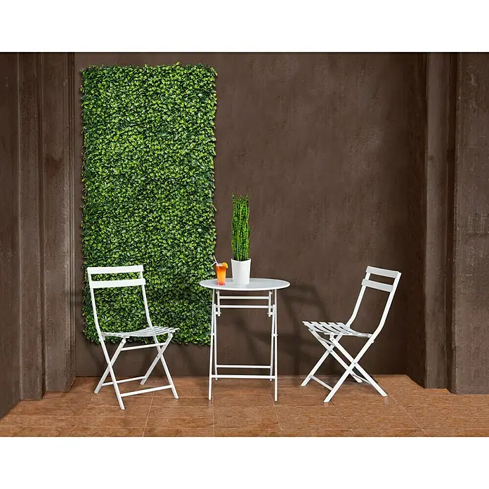 Nortene Jardín vertical Laurel - Plástico, L x An: 100 x 100 cm - Una elegante escena al aire libre con un conjunto de bistró blanco, con una mesa y dos sillas, sobre una pared de plantas verdes vibrantes.