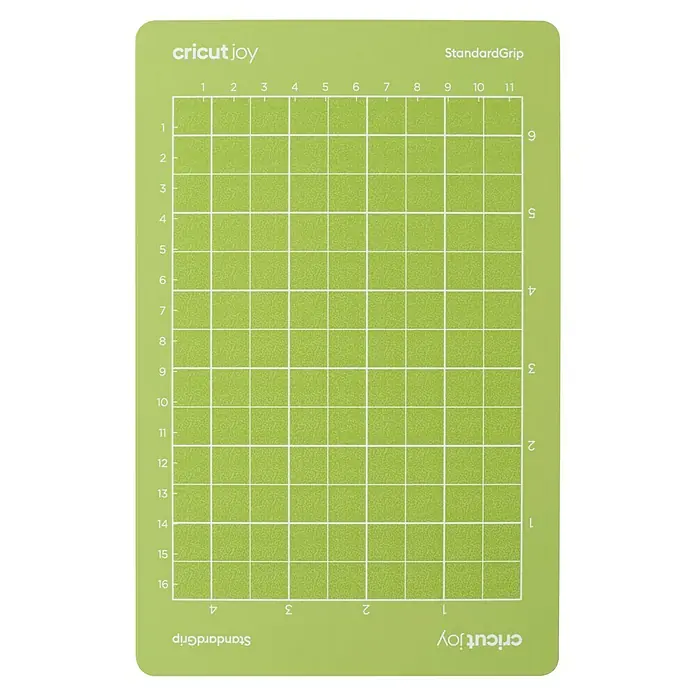 Cricut Joy Schneidematte StandardGrip - L x B: 16,5 x 11,4 cm, Passend für: Cricut Joy Schneideplotter - Nahaufnahme einer Cricut Joy StandardGrip Schneidematte, die eine grüne Oberfläche mit einem Rastermuster und Markierungen für präzise Schnitte zeigt.