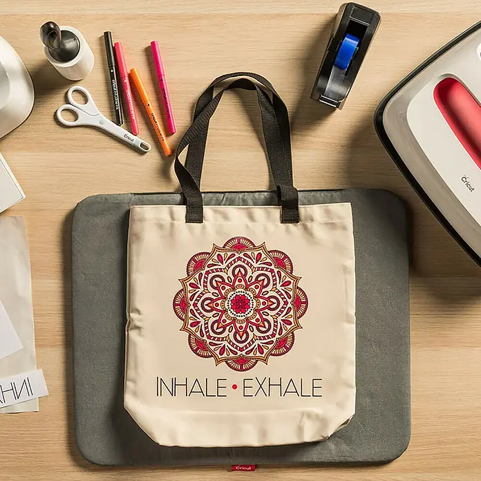 Cricut Filzstift-Set Infusible Ink Filzstift-Set Neon - 5 -tlg., Neon, Strichstärke: 1 mm - Nahaufnahme einer Tragetasche mit einem Mandala-Design und dem Text "Inhale Exhale", umgeben von Bastelutensilien.
