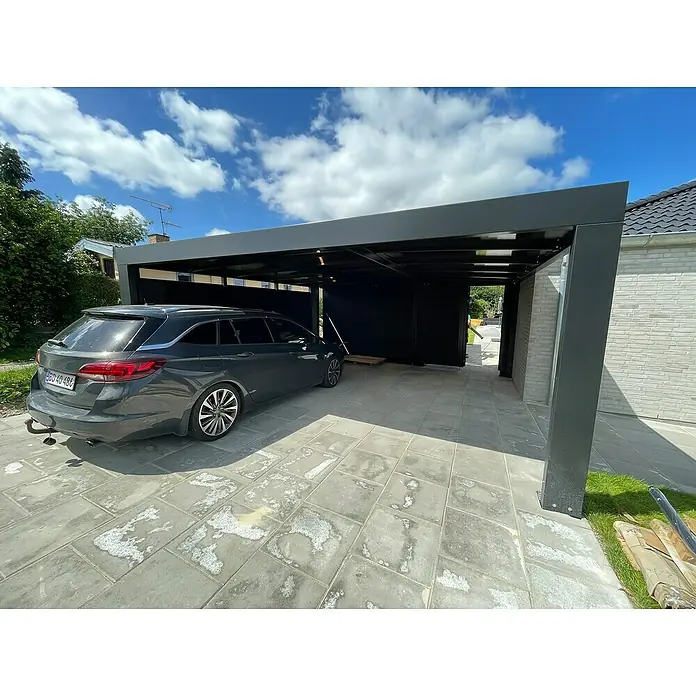 Allview Carport Cubus Lange Ausführung (Doppel) - Außenmaß inkl. Dachüberstand (B x T): 5,8 x 5,8 m, Grau - Ein graues Auto parkt unter einem modernen Carport mit Flachdach und grauen Säulen auf einem gepflasterten Hof. Schönes Design!