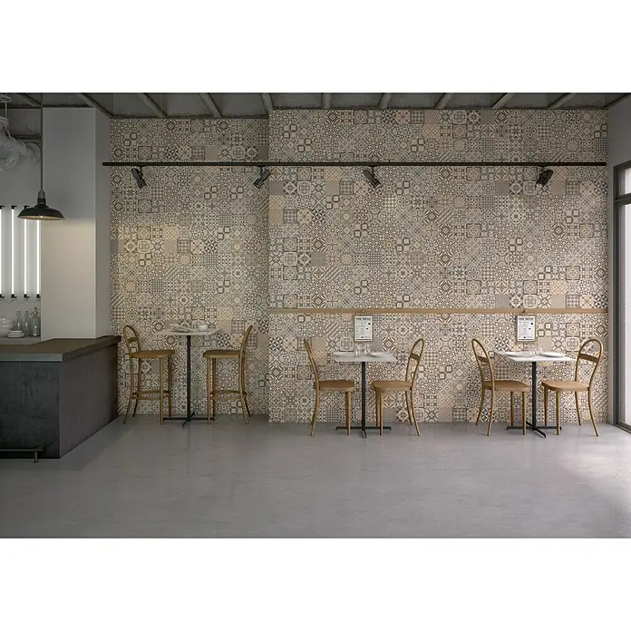 Bariperfil Perfil de acabado angular Hidráulico Crema - 2,6 m x 3 cm - Interior de un restaurante con mesas y sillas frente a una pared de azulejos de cemento de estilo vintage, creando un ambiente acogedor.