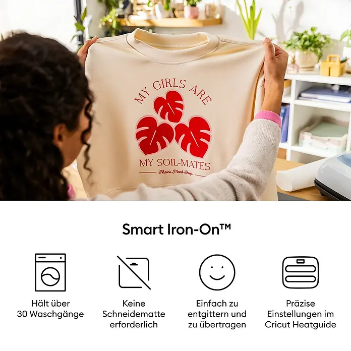 Cricut Aufbügelfolie Smart Iron-On - Ozean Blau, L x B: 91,4 x 33 cm, Passend für: Cricut Explore® 3 & 4, Cricut Maker® 3 & 4 - Das Bild zeigt ein beigefarbenes Sweatshirt mit dem Aufdruck "My Girls Are My Soil-Mates" in roter Schrift, verziert mit Monstera-Blattmotiven.
