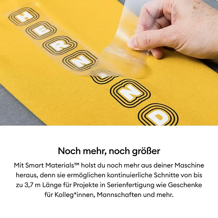 Cricut Joy Aufbügelfolie Smart Iron-On - Schwarz, L x B: 61 x 13,9 cm, Passend für: Cricut Joy Schneideplotter - Gelbes T-Shirt mit dem Aufdruck "HERND", wobei eine Hand eine transparente Folie abzieht.