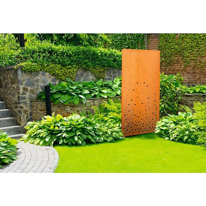 Palatino Space Vertical Sichtschutzelement Vapor - 87 x 180 cm, Edelrost, Vapor - Eine rostige Metallwand mit kreisförmigen Ausschnitten in einem üppigen Garten, die einen modernen Akzent setzt.