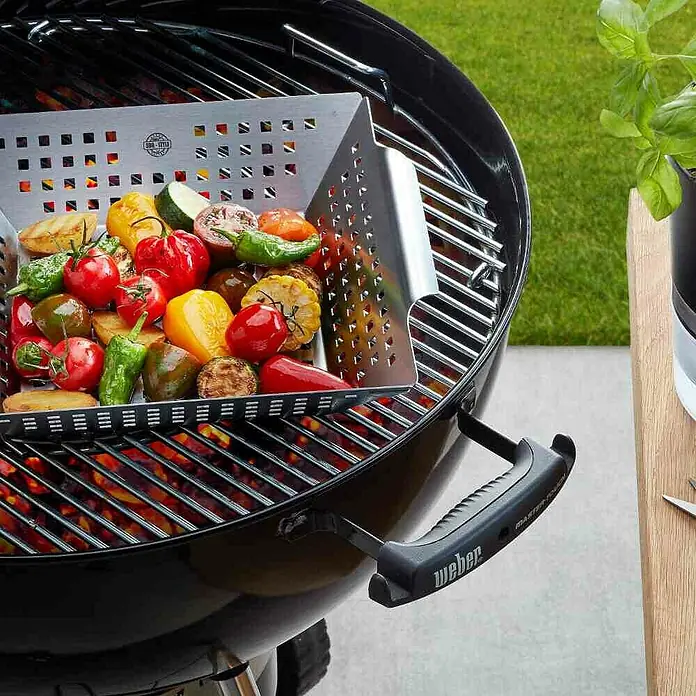 Dick Grillpfanne BBQ - L x B: 33 x 28 cm, Höhe: 7,5 cm, Edelstahl - Gemüsekorb auf einem schwarzen Weber Grill. Das Zubehör ist perfekt zum einfachen Grillen von Gemüse und kleinen Speisen.