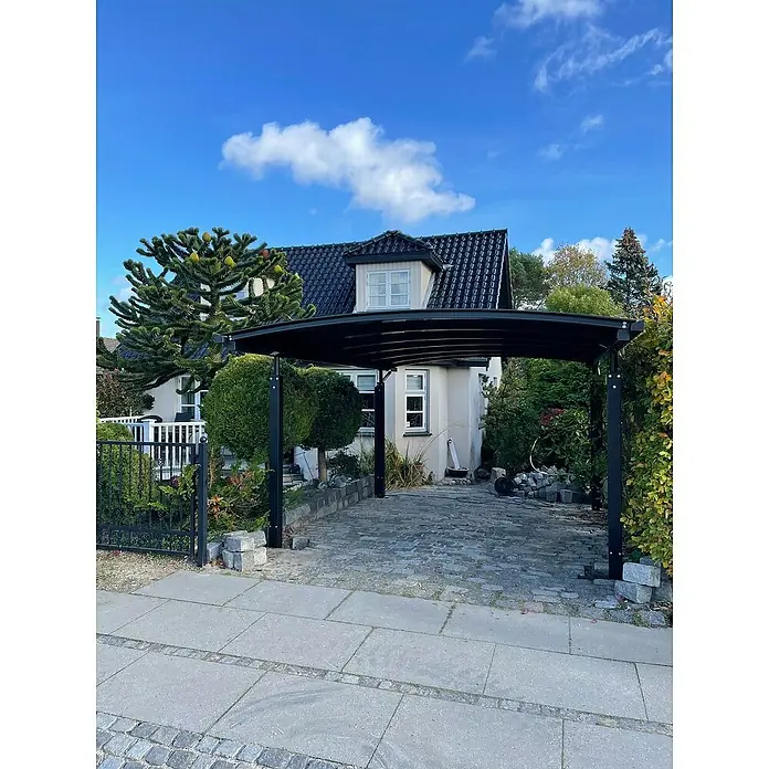 Allview Carport Calux - Außenmaß inkl. Dachüberstand (B x T): 3,52 x 5,52 m, Grau - Eine moderne Carport-Konstruktion aus dunklem Metall, die einen gepflasterten Hofbereich überspannt und Schutz für Fahrzeuge bietet.