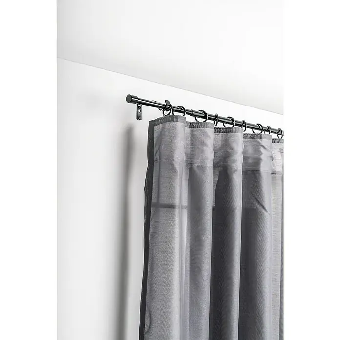 Komplettgarnitur Cap - Schwarz, 120 cm - 210 cm, Metall, Ausziehbar - Graue Vorhänge hängen an einer schwarzen Gardinenstange mit schwarzen Ringen vor einer weißen Wand.