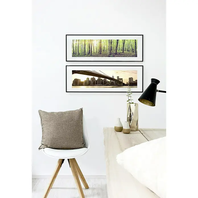 Nielsen Alurahmen C2 - 60 x 80 cm, Schwarz - Einrichtungselement mit einem Stuhl mit Kissen, einer Lampe und Bildern an der Wand, die eine warme und einladende Atmosphäre schaffen.