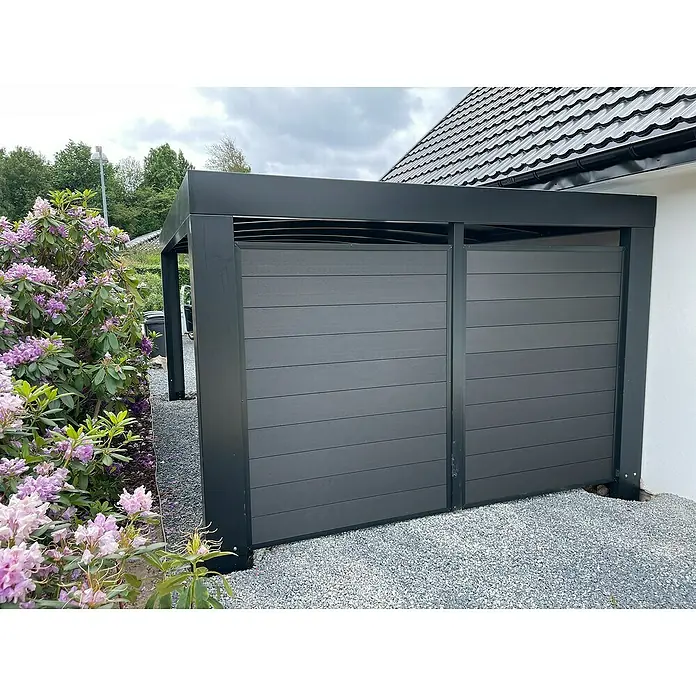 Allview Wandelement Cubus Endwand - Passend für: Allview Einzelcarport Cubus - Diese Aufnahme zeigt eine moderne graue Mülltonnenbox mit Holzeffekt-Verkleidung vor einem Haus. Sie dient als stilvolle Aufbewahrungslösung.