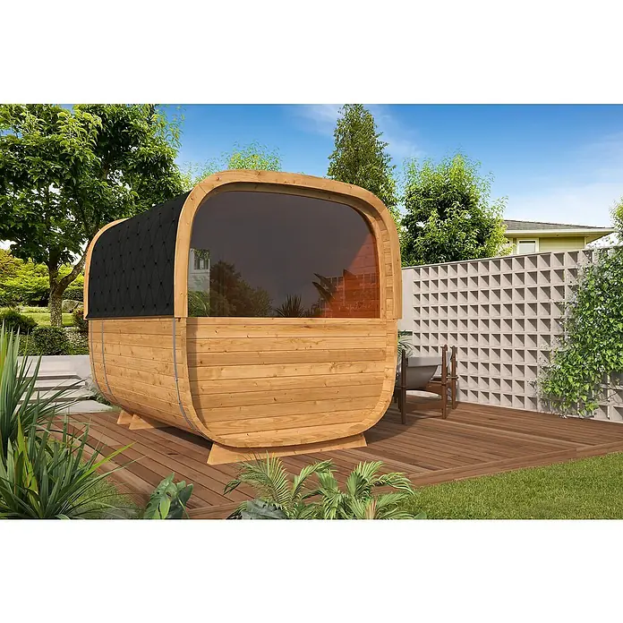 Tuindeco Saunahaus Cube Rovaniemi - L x B x H: 286 x 219 x 234 cm, Ohne Ofen, ½‑Panorama‑Fenster - Ein Fass-Sauna aus Holz mit einem schwarzen Dach und einer großen Fensterfront auf einer Holzterrasse im Garten.