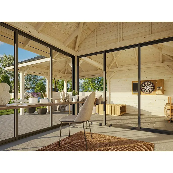 Palmako Caseta de jardín Bianca Set 210 Slide - Medidas ext. (An x Pr): 672 x 672 cm, Madera, Natural - Casa de madera luminosa con grandes ventanales que ofrecen vistas a un jardín y patio. Dentro, una mesa y una silla se asientan sobre una alfombra.
