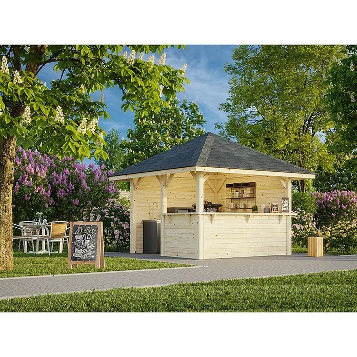 Palmako Pérgola estándar Bianca Set 103 - L x An: 384 x 384 cm, Madera, Natural - Vista del jardín con una glorieta de jardín de madera con techo oscuro, que sirve como cafetería, rodeada de plantas y árboles en flor.