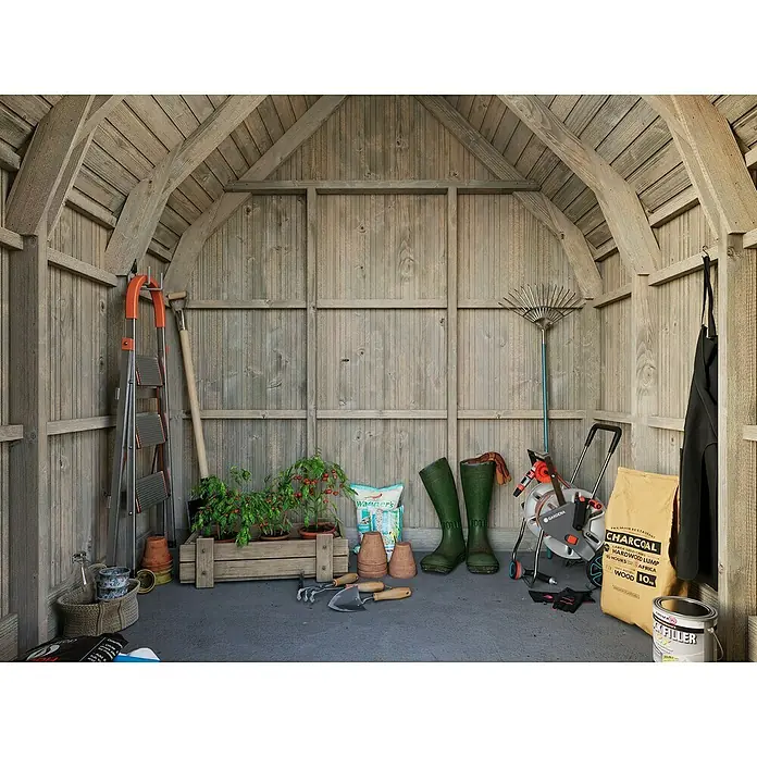 Palmako Caseta de jardín Emilia - Medidas ext. (An x Pr): 240 x 187 cm, Madera, Gris - Toma de un cobertizo de madera con herramientas de jardinería como palas, botas, plantas y equipos, destacando el ambiente general de jardinería.
