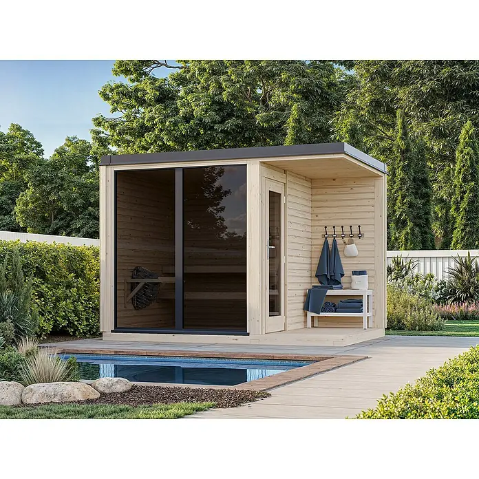 Palmako Saunahaus Sarah - Ohne Ofen, Natur, L x B x H: 222 x 322 x 237 cm - Die Außensauna aus hellem Holz mit dunklen Akzenten neben dem Pool, umgeben von Grün, lädt zum Entspannen ein.
