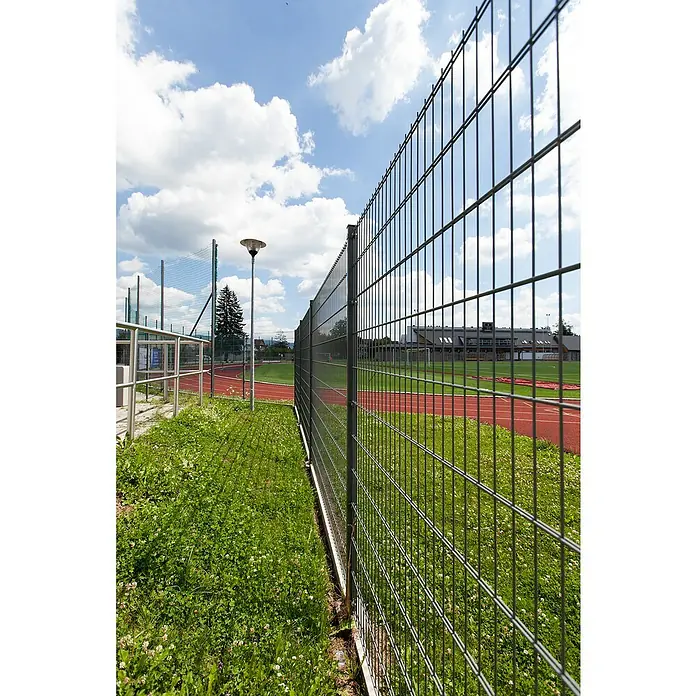 Mattenzaun Vega 2D - Anthrazit, B x H: 2.500 x 1.030 mm, Stahl - Blick auf einen Gitterzaun, der ein Sportfeld umgibt, bei sonnigem Wetter. Er bietet Sicherheit und begrenzt den Zugang.