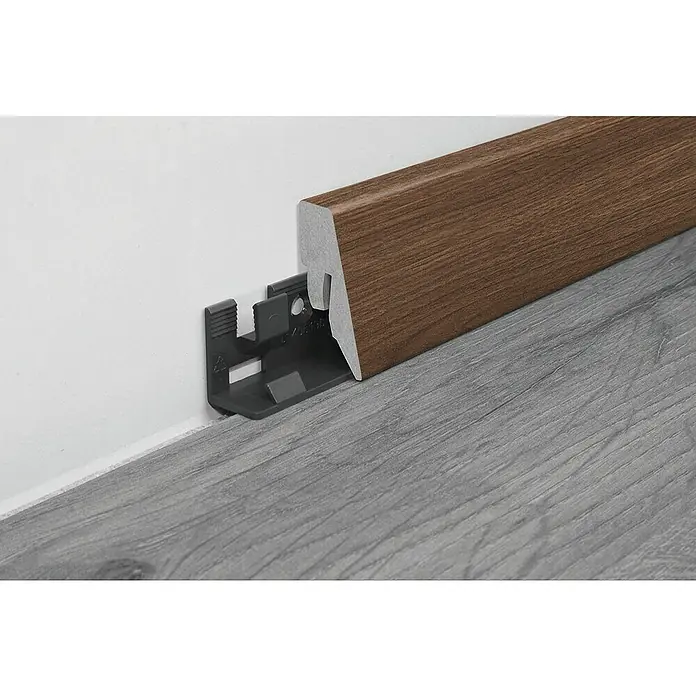 LOGOCLIC Sockelleiste K40 C - 260 cm x 19 mm x 40 mm, MDF, Eiche Hickory Donada - Braune Sockelleiste mit Clip-System zur einfachen Befestigung an einer weißen Wand über einem grauen Holzboden.