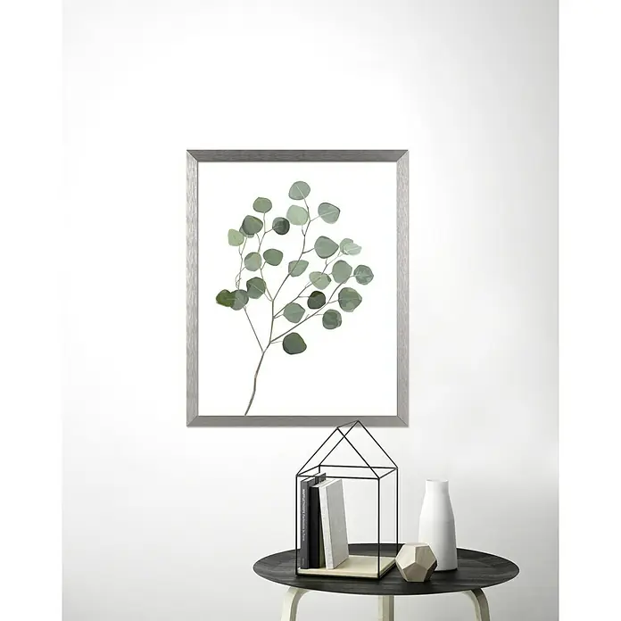 Accent Alurahmen StarDIN A4 / 21 x 29,7 cm, Silber - Gerahmtes Eukalyptusbild über einem Beistelltisch mit Buchhalterhaus, Büchern, einer Vase und einem geometrischen Dekoelement.