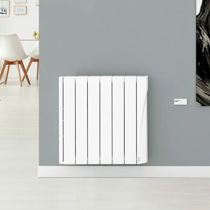 Voltomat Emisor térmico WiFi I - 1.000 W, Blanco, 9,5 x 58 x 57,5 cm, Cerámico - Un radiador blanco de pared con múltiples paneles verticales sobre una pared gris. Su diseño moderno se integra perfectamente en el espacio.