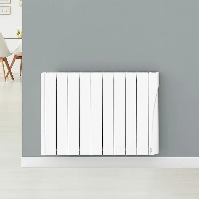 Voltomat Emisor térmico WiFi I - 1.500 W, Blanco, 9,5 x 82 x 57,5 cm, Cerámico - Primer plano de un radiador eléctrico blanco contra una pared gris, que proporciona una calefacción de habitación eficiente.