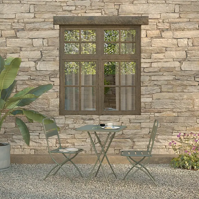 Feros Balkonmöbel-Set Breeze - 3 -tlg., Metall, Grün - Gartenszene mit grünem Bistro-Set unter einem Fenster, bestehend aus Tisch und Stühlen, ideal für entspannte Stunden im Freien.