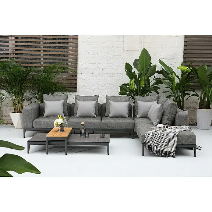 Loungetisch Athene - L x B x H: 144 x 74 x 36 cm, Metall, Anthrazit - Graues modulares Outdoor-Sofa-Set mit Couchtisch und Pflanzen auf einer Terrasse mit weißer Ziegelwand im Hintergrund.