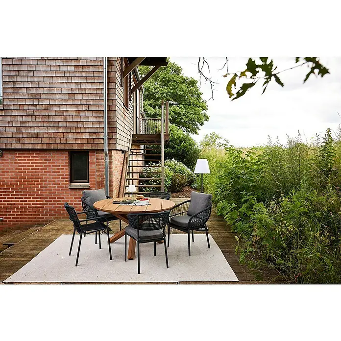 Barths Gartensessel Tropea - Aluminium, Seilgeflecht, Anthrazit, B x T x H: 63,5 x 64,5 x 78,5 cm - Einladender Outdoor-Essbereich mit einem runden Holztisch und stilvollen Stühlen auf einem eleganten Teppich vor einer rustikalen Hauswand.