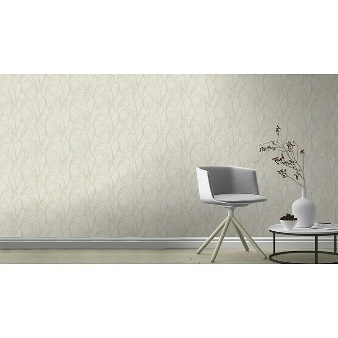 Rasch Tapetenwechsel Vliestapete Äste - Beige/Weiß, Floral, 10,05 x 0,53 m - Elegantes Interieur mit einer stilvollen Tapete, einem modernen Stuhl und einem dekorativen Beistelltisch mit Vase und Accessoires.