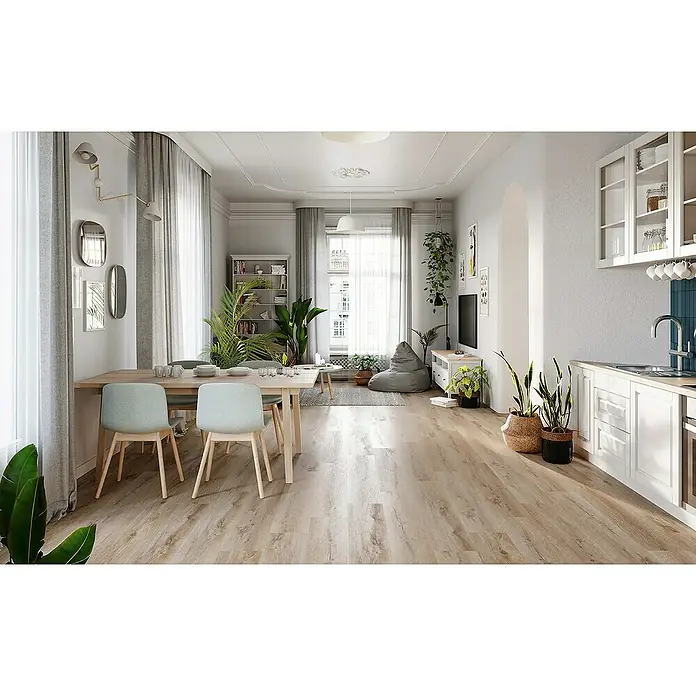 Vinylboden Silent - Sherman Eiche, Landhausdiele, 1.220 x 229 x 5,3 mm - Heller, moderner Raum mit Holzboden, Esstisch mit hellblauen Stühlen und Pflanzen. Die Küche ist mit weißen Schränken ausgestattet.