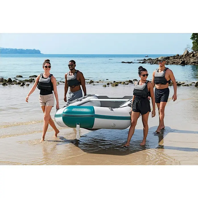 Bestway Hydro Force Schlauchboot-Set Mirovia Pro™ - L x B x H: 330 x 162 x 44 cm, Geeignet für: Max. 5 Personen, Nutzlast: 640 kg - Vier Personen tragen ein Hydro-Force-Schlauchboot am Strand. Das Boot ist weiß mit grünen Akzenten und bereit für den Einsatz auf dem Wasser.