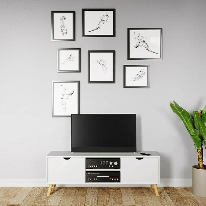 Phönix Scandi Lowboard - L x B x H: 45 x 145 x 51 cm, Weiß - Ein moderner Wohnraum mit einem eleganten weißen Medienschrank, der eine schlanke schwarze Fernsehgerät und Audio-Geräte trägt, umgeben von Kunstwerken.