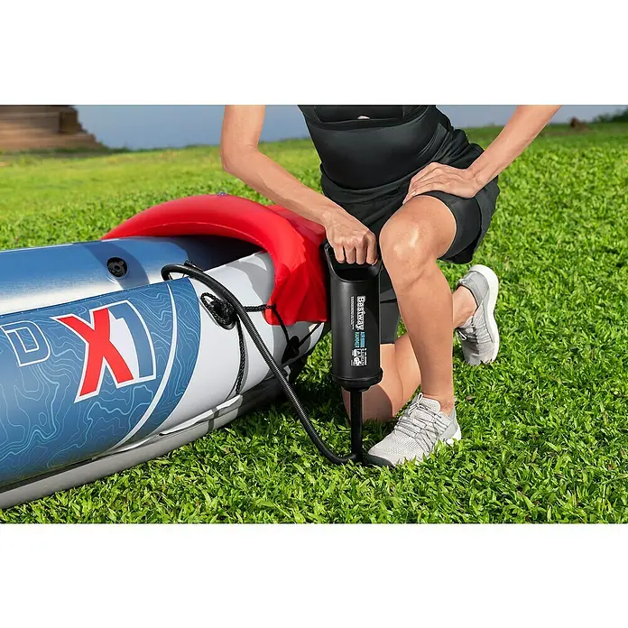 Bestway Hydro Force Kajak Rapid X1 - L x B: 290 x 91 cm, Nutzlast: 120 kg, Geeignet für: 1 Person - Eine Person pumpt ein Bestway Hydro-Force Schlauchboot mit einer Luftpumpe auf einer grünen Wiese auf.