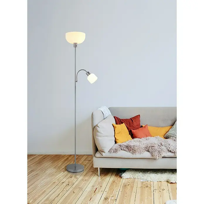 Globo Stehleuchte Hinton - 60 W, Höhe: 178 cm, Silber, E27 - Stehlampe mit Leselampe in modernem Design. Die Lampe ist silbern und steht neben einem Sofa mit Kissen.